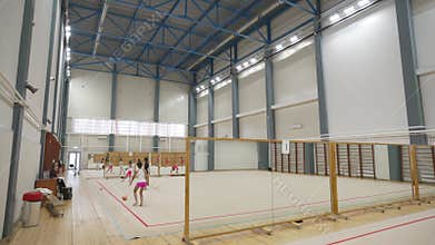 Team of little girls gymnasts train with inventory in gym