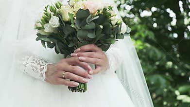 Caucasian bride holding a wedding bouquet, hands and bouquet close up