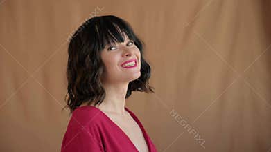 Beautiful woman laughs with bright teeth smile in red top, playful expression. Red lipstick make-up and wavy bob hair. Lifestyle