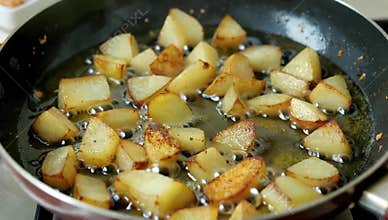 Golden fried potatoes cooking in a pan with hot oil for a delicious and crispy side dish or snack ready to be served fresh