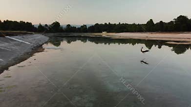 Stork Takes Flight at Sunset: A Serene Lakeside
