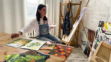 A joyful artist proudly showcasing their colorful paint brushes in a bright and inspiring studio environment
