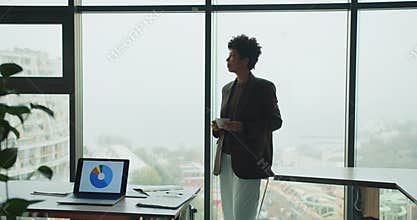 Financial analyst reviewing data visuals with city view behind