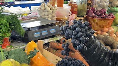 Male hand choosing grapes in the supermarket, putting to the basket