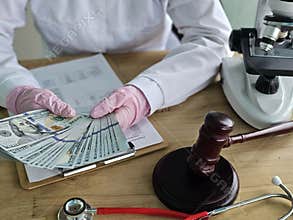 Researcher handling cash while examining samples in a laboratory