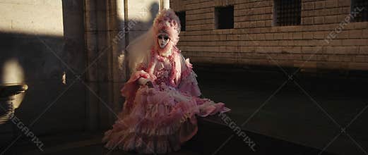 Portrait of woman in pink carnival costume with lace and veil at St Mark Square