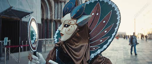 Portrait of woman in carnival costume with mask and mirror at Saint Mark Square