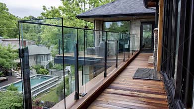 Midrange view of a sleek glass deck railing being installed highlighting modern design and unobstructed views for safe