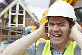 Construction Worker Suffering From Noise Pollution On Building Site