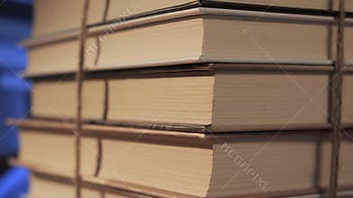 Stack of books tied with string showing pages edges in close up