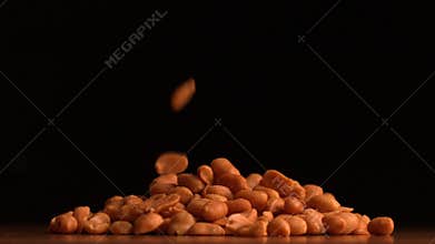 Peanuts pouring on black background