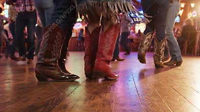 People in cowboy boots line dancing