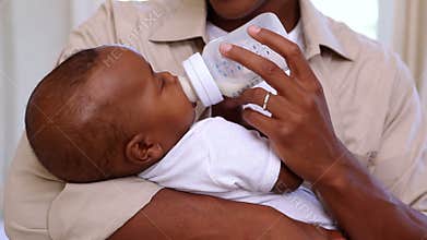 Happy father feeding cute baby son