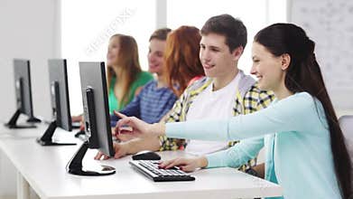 Smiling students working with computers at school