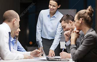 Smiling female boss talking to business team