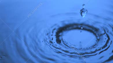 Water dripping in super slow motion on a surface