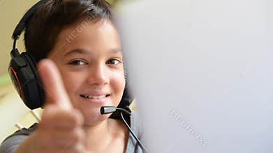 Child happy listen music and playing on the computer with headphones outdoor