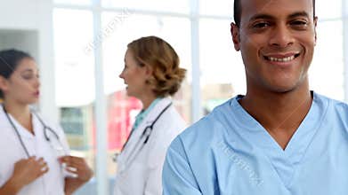 Nurse smiling and standing in front of medical team