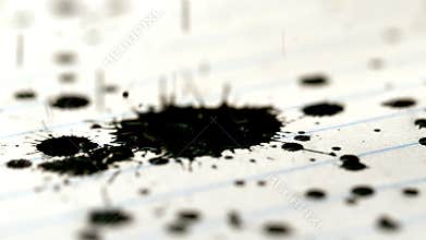 Black ink falling on lined paper