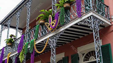 Festive mardi gras balcony decorated with colorful beads and mask in new orleans celebrating vibrant annual carnival tradition in
