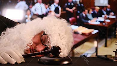 Exhausted judge sleeping with gavel in courtroom