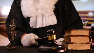 Judge in robe striking gavel in courtroom