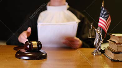 American judge striking gavel pronouncing sentence in courtroom