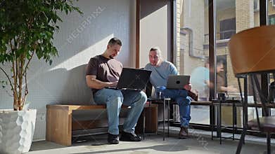 Programmers discussing over laptop working at startup. Office, business and friends together in teamwork with notebook