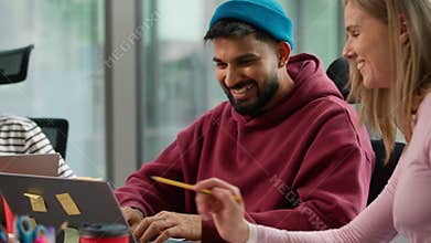 Happy smiling positive diversity business team in informal startup office talking friendly carefree working pointing in