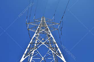 High power tower pole against blue sky