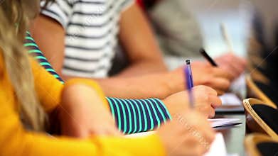 Row of students taking notes in class