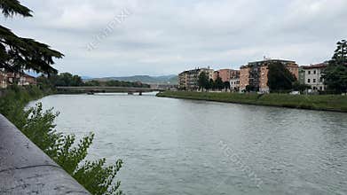 Adige river flowing through verona city on cloudy day