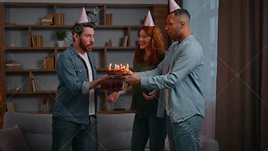 Three multiracial friends at home party birthday congratulation couple Caucasian woman with Latino American male