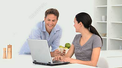 Woman showing her boyfriend something on her laptop