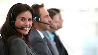 Smiling customer service agents working in a call center