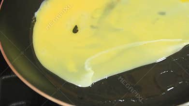 A person frying eggs in a frying pan. cook the beaten eggs