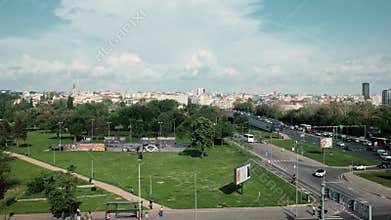 Cityscape view with modern skyscrapers, busy roads, traffic, buses and green areas under a partly cloudy sky. Belgrade, Serbia -
