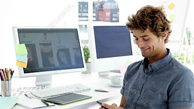 Amused creative designer text messaging with his phone