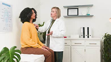 Experienced Female Doctor Conducts Thorough Consultation With Diverse Young Patient Using Stethoscope