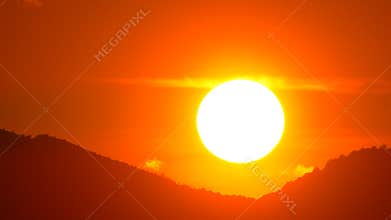Sunset Sun Sky - A vibrant sunset with a bright sun setting behind silhouetted hills and a fiery orange sky.