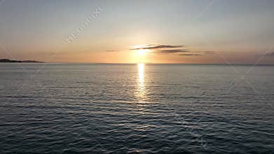 erial Drone Shot Flying Over Calm Sea Towards a Beautiful Sunset in greece