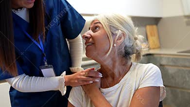 Supportive nurse comforting senior patient at home