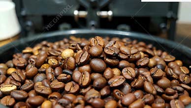 Roasted coffee beans in a black bowl ready for grinding and brewing a delicious hot beverage