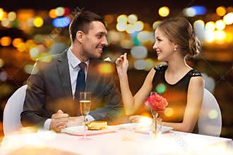 Smiling couple eating dessert at restaurant