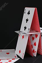 House of playing cards on black background