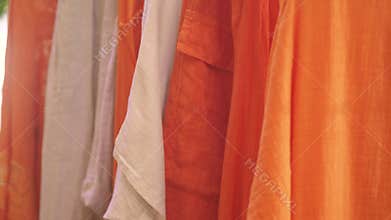 Bright orange fabrics hanging in a market stall