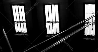 Somber Atmosphere Inside a Dark Room with Barred Windows