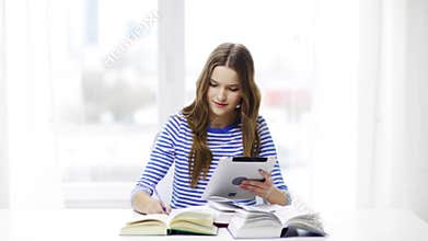 Smiling student girl with tablet pc and books