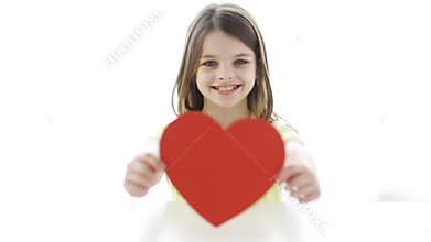 Smiling girl with red heart at home