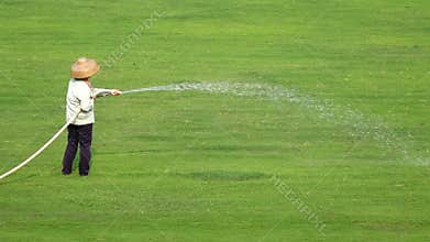 Worker watering the grassland
